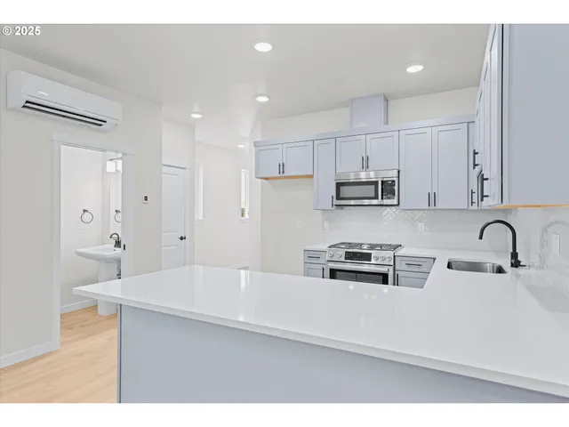 a kitchen with kitchen island a sink stainless steel appliances and cabinets
