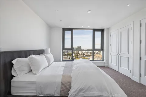 a spacious bedroom with a bed and a large window