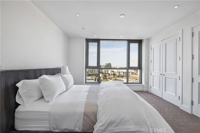 a spacious bedroom with a bed and a large window