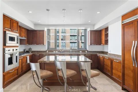 a kitchen with granite countertop wooden cabinets and stainless steel appliances