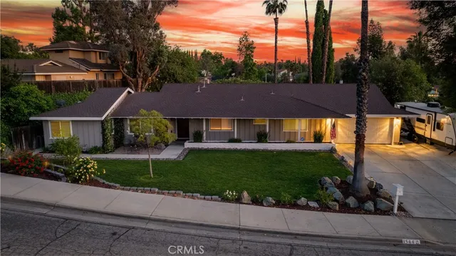 a front view of a house with a yard and potted plants