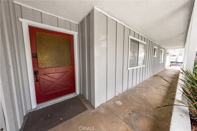 a view of a hallway with wooden floor and door