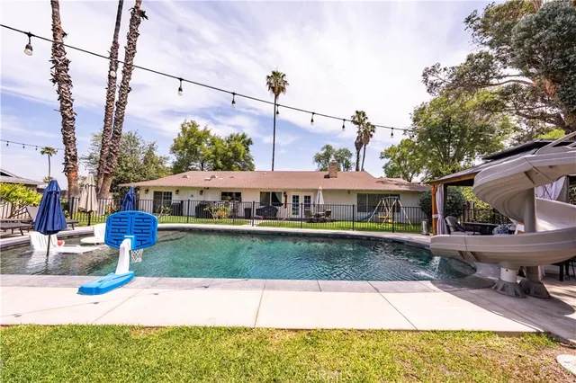 a view of a house with pool and sitting area