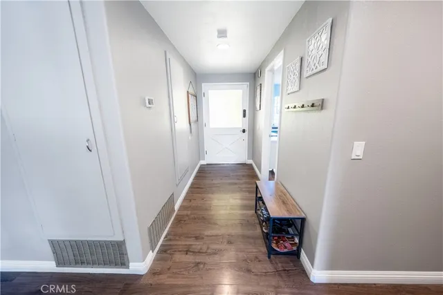 a hallway with painting on the wall and a potted plant