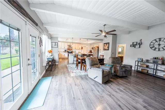 a living room with stainless steel appliances kitchen island granite countertop furniture and a wooden floor