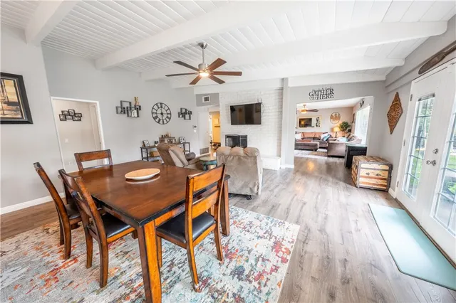 a kitchen with granite countertop a table chairs microwave and cabinets