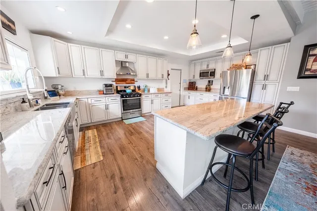 a large kitchen with stainless steel appliances granite countertop a lot of counter space and wooden floors