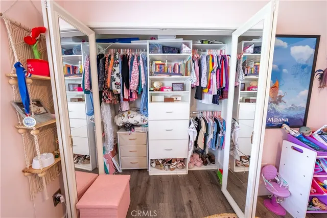 a view of a hallway with white cabinets and wooden floor