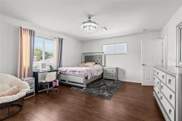 a bedroom with a bed and a table chair