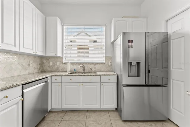 a kitchen with stainless steel appliances granite countertop a refrigerator and a sink