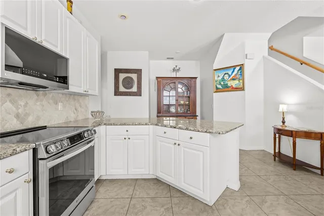 a kitchen with granite countertop a sink stove and microwave