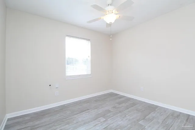 an empty room with wooden floor and window