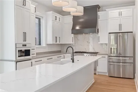 a large white kitchen with a large window