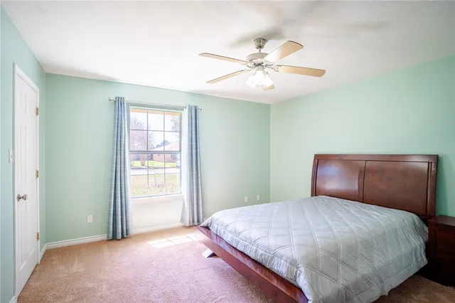 a bedroom with a large bed and a chandelier