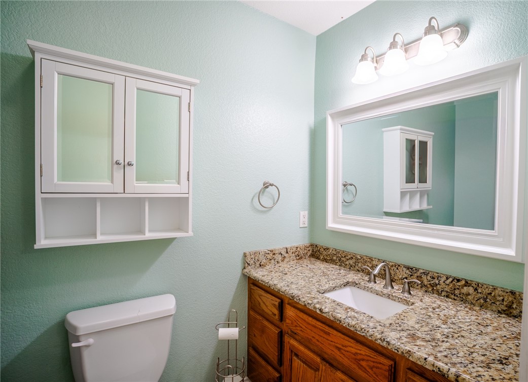 1016 Clark Street Mexia, TX 76667 - Photo 15 of 36 a bathroom with a granite countertop sink and a toilet