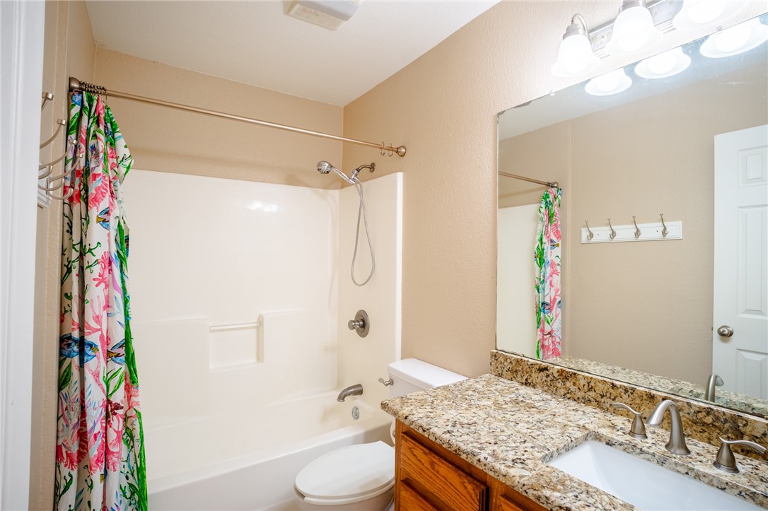 1016 Clark Street Mexia, TX 76667 - Photo 19 of 36 a bathroom with a granite countertop sink toilet and shower