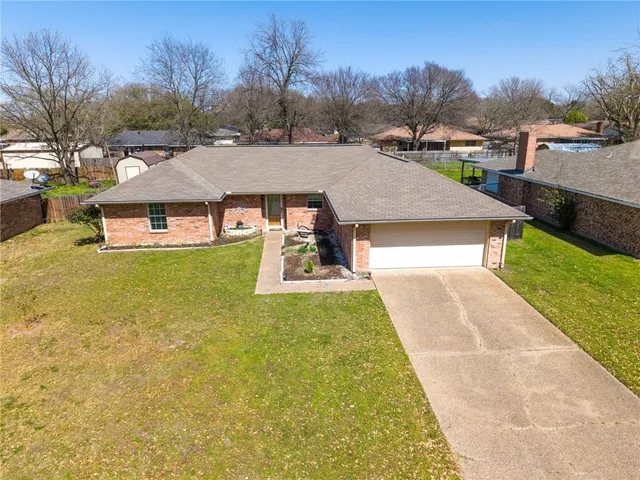 a aerial view of a house with table and chairs under an umbrella