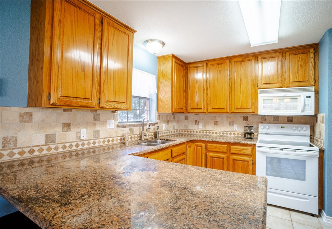 1016 Clark Street Mexia, TX 76667 - Photo 5 of 36 a kitchen with stainless steel appliances granite countertop a sink and cabinets