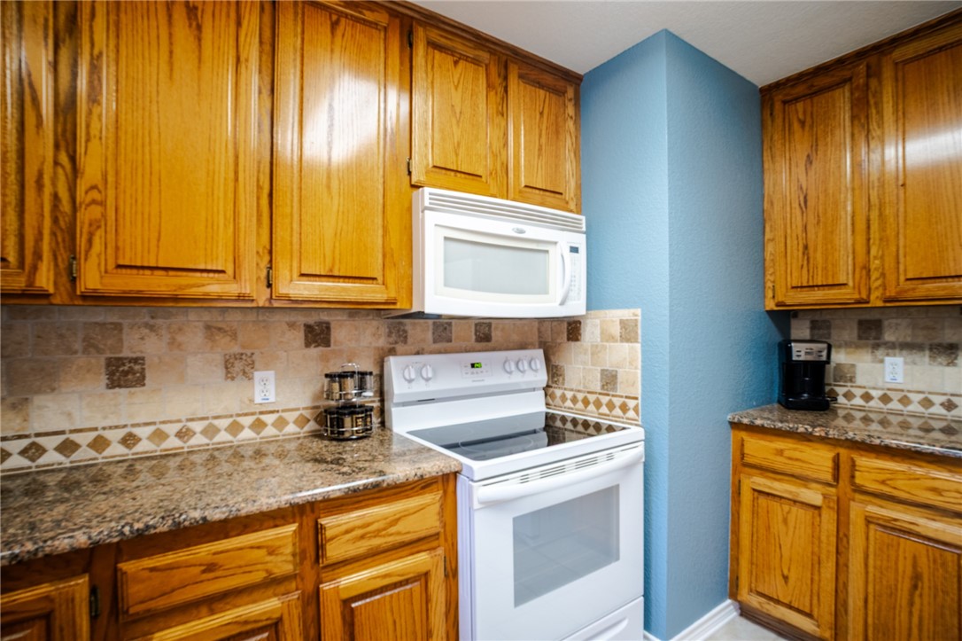 1016 Clark Street Mexia, TX 76667 - Photo 6 of 36 a kitchen with granite countertop cabinets stainless steel appliances and sink