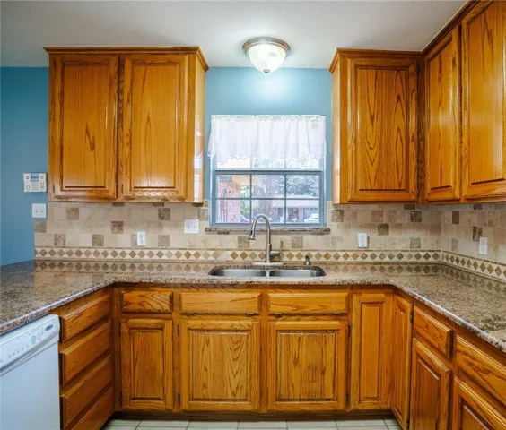 a kitchen with stainless steel appliances granite countertop wooden cabinets a sink and a window