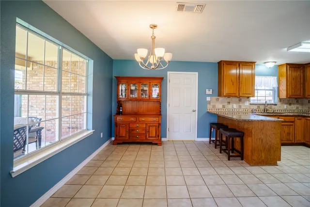 a view of kitchen with granite countertop a sink and a stove top oven