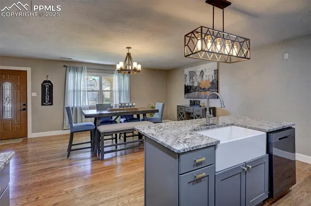 a view of a dining room with furniture a chandelier and wooden floor