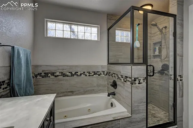 a large bedroom with bed and paintings on the wall