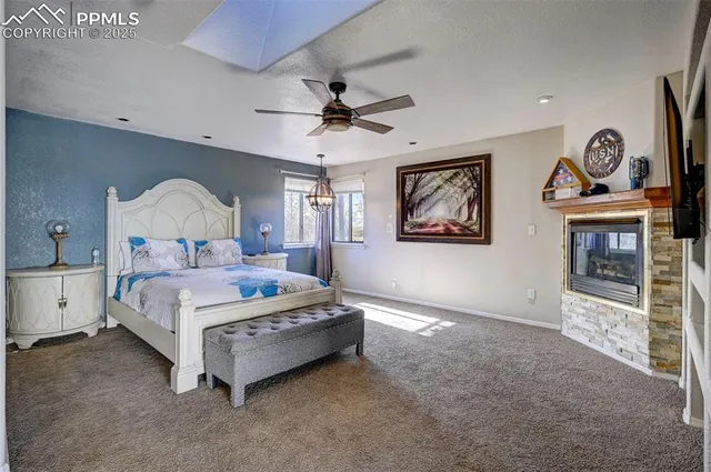 a bedroom with a bed mirror on desk and a chandelier
