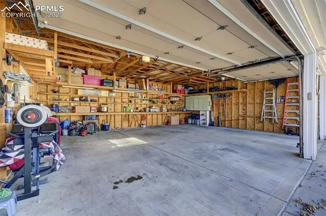 a view of a town with barn and large trees