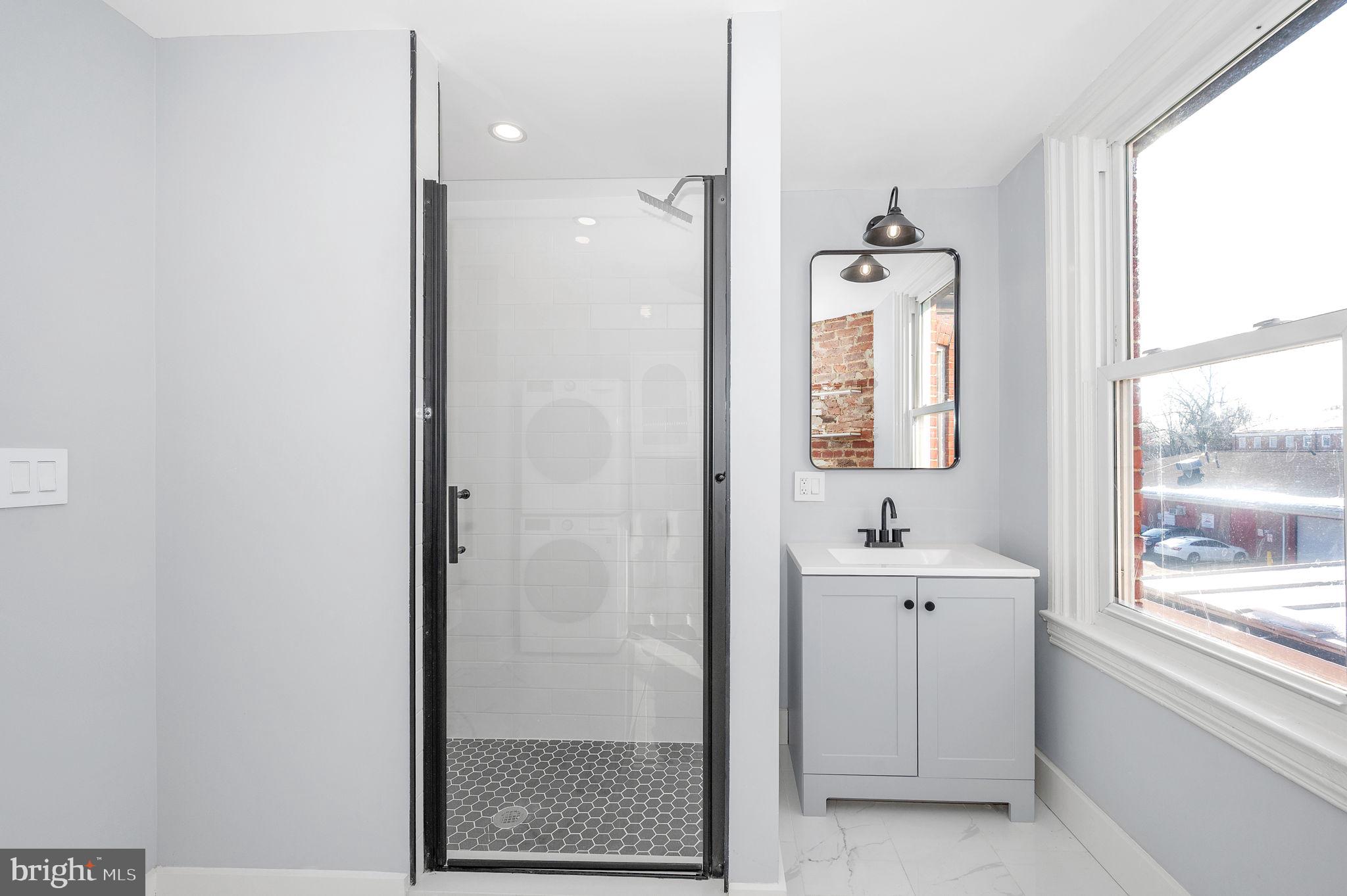 230 South Market Street, Unit 3 Frederick, MD 21701 - Photo 12 of 22 a bathroom with a bathtub a shower a sink and a window