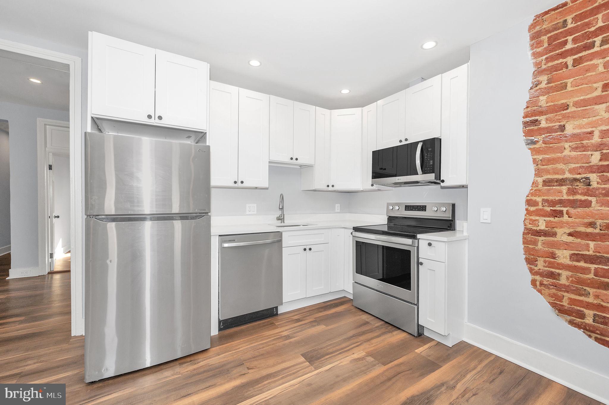 230 South Market Street, Unit 3 Frederick, MD 21701 - Photo 5 of 22 a kitchen with cabinets stainless steel appliances and wooden floor