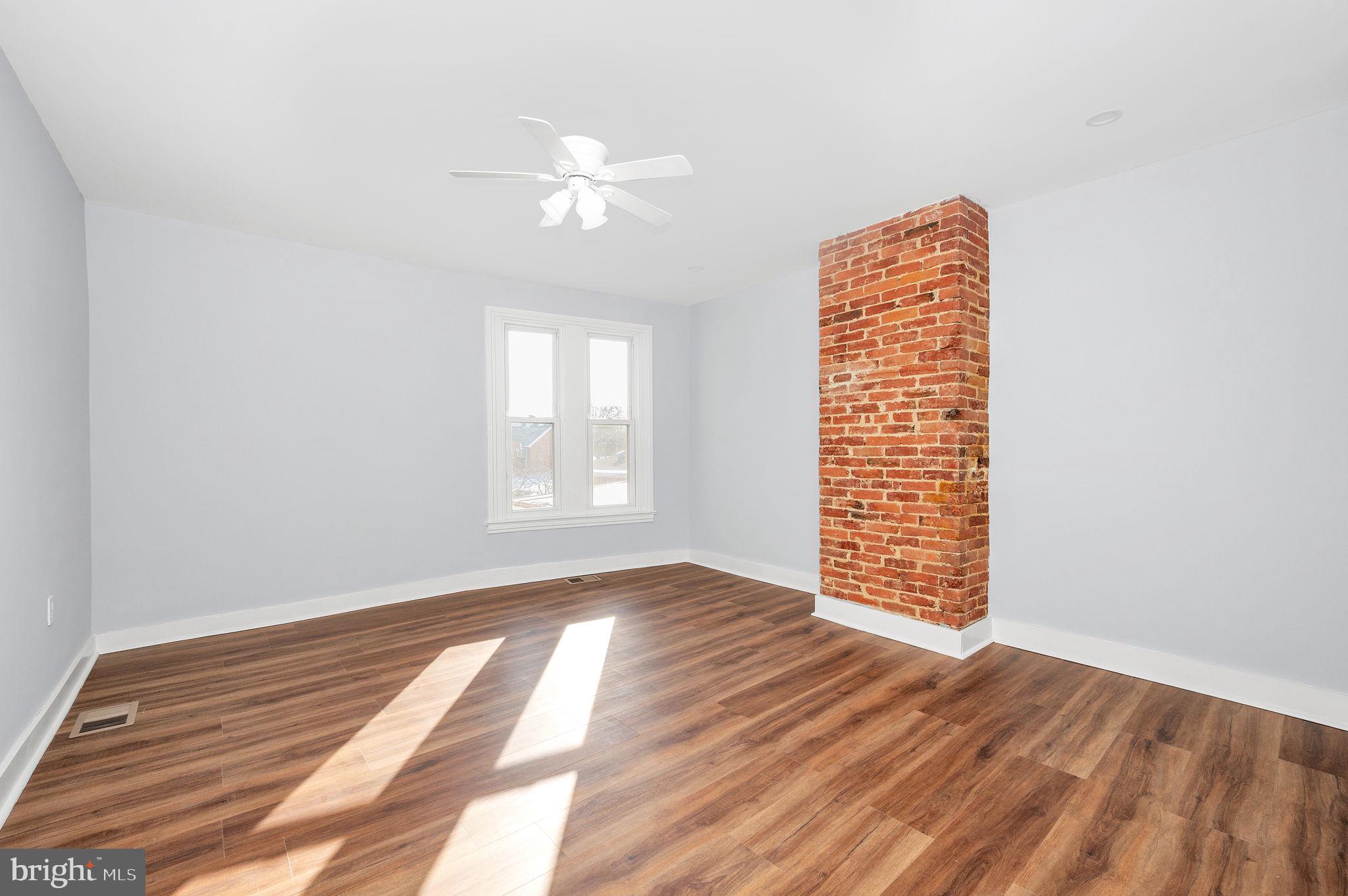 230 South Market Street, Unit 3 Frederick, MD 21701 - Photo 7 of 22 a view of an empty room with wooden floor and a window