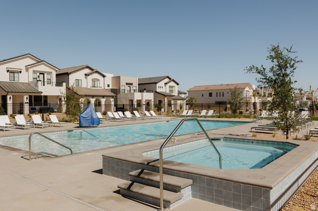 629 Spring Lily Drive St. George, UT 84790 - Photo 49 of 50 Resident Community swimming pool with an integrated spa, surrounded by a concrete deck and multiple lounge chairs