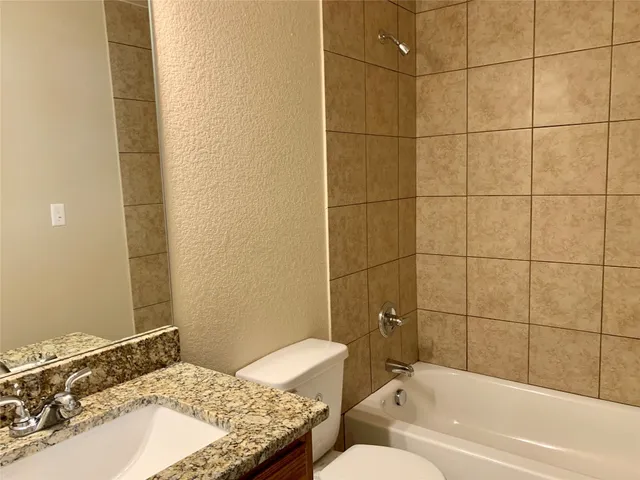 a bathroom with a granite countertop sink toilet and bathtub