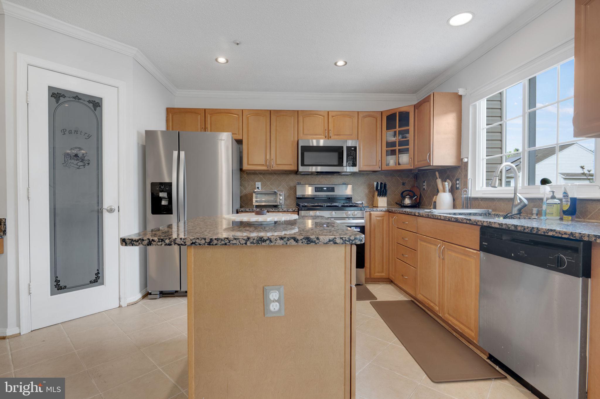 2348 Cold Meadow Way Silver Spring, MD 20906 - Photo 13 of 30 a kitchen with stainless steel appliances granite countertop a refrigerator a stove a sink a microwave and cabinets
