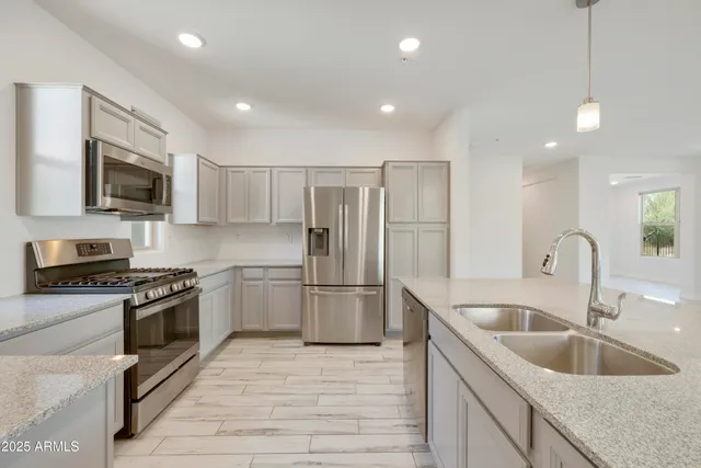a kitchen with a sink stainless steel appliances and white cabinets