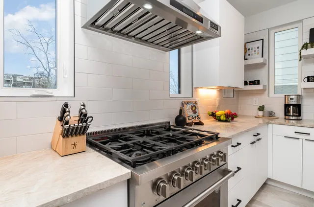 a kitchen with a stove a sink and cabinets