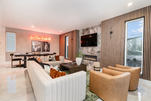 a living room with furniture a flat screen tv and a large window