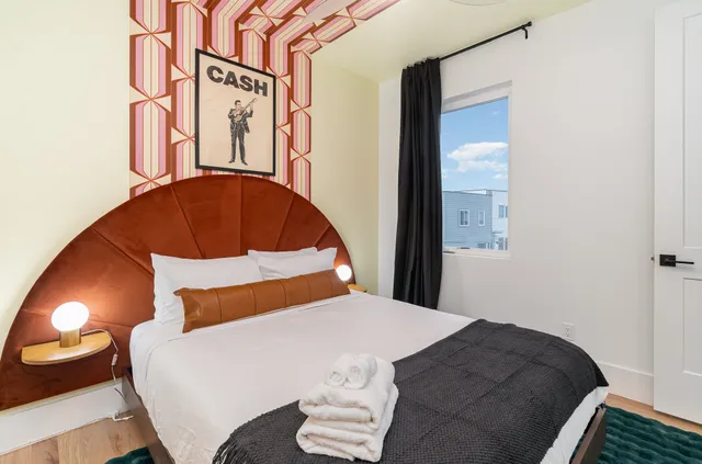 a bedroom with a bed and a painting on the wall