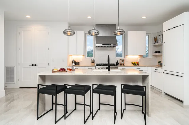a kitchen with stainless steel appliances a sink and a refrigerator