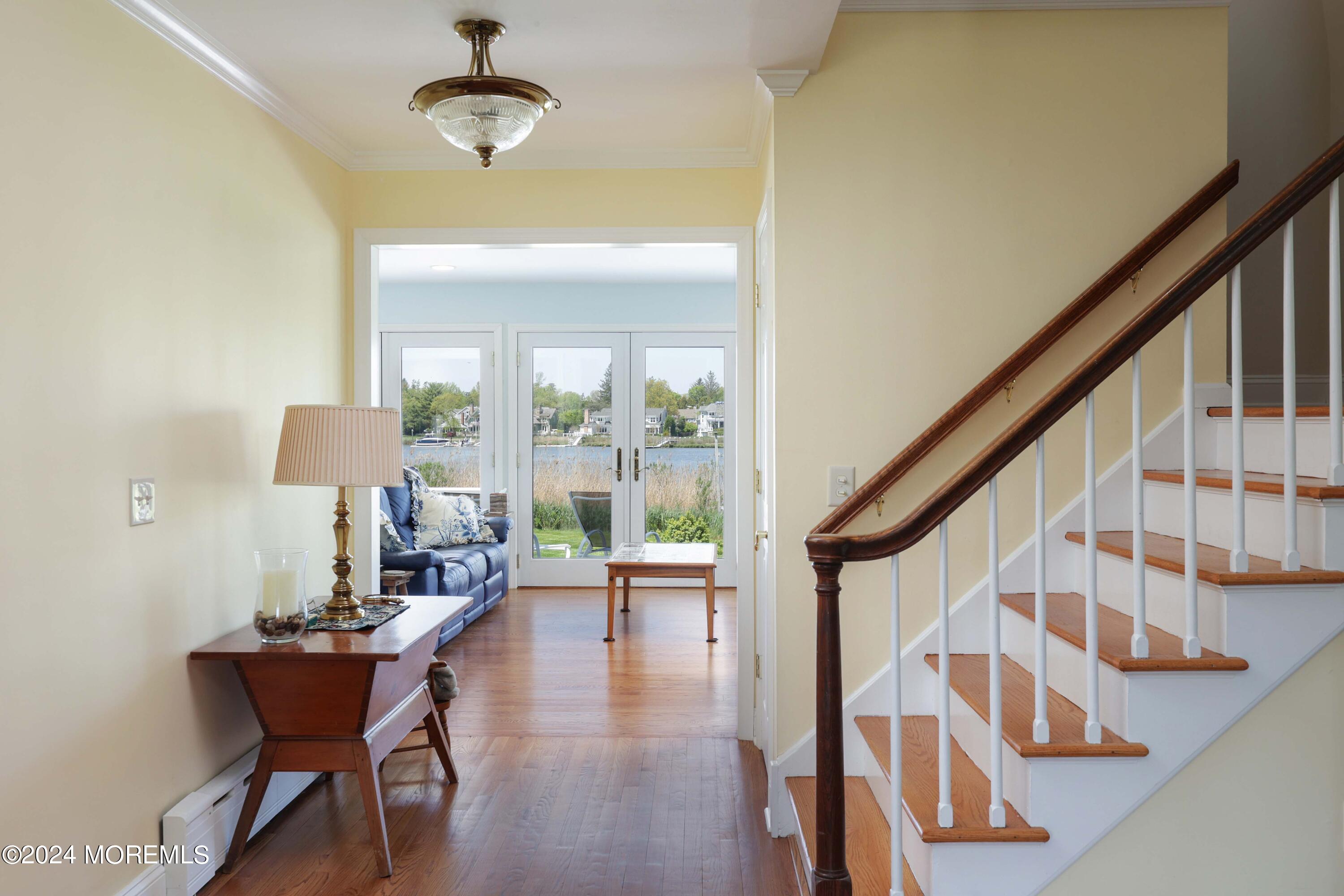 121 Horseneck Road Oceanport, NJ 07757 - Photo 7 of 48 a dining room with wooden floor a chandelier a glass table and windows