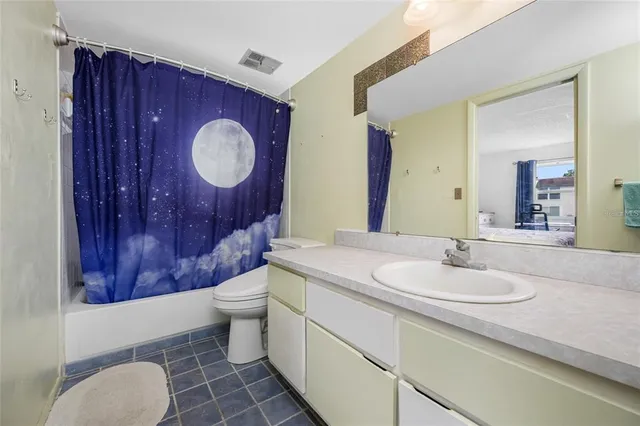 a bathroom with a toilet sink vanity granite and mirror