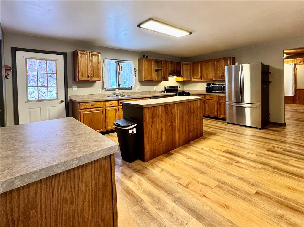 237 Mason Street Kennerdell, PA 16374 - Photo 13 of 25 a kitchen with stainless steel appliances kitchen island granite countertop a refrigerator a sink dishwasher and wooden cabinets with wooden floor