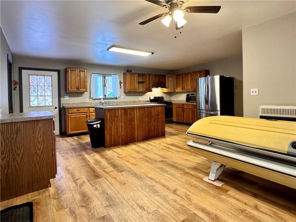 237 Mason Street Kennerdell, PA 16374 - Photo 14 of 25 a large kitchen with kitchen island a stove a sink dishwasher and a dining table with wooden floor