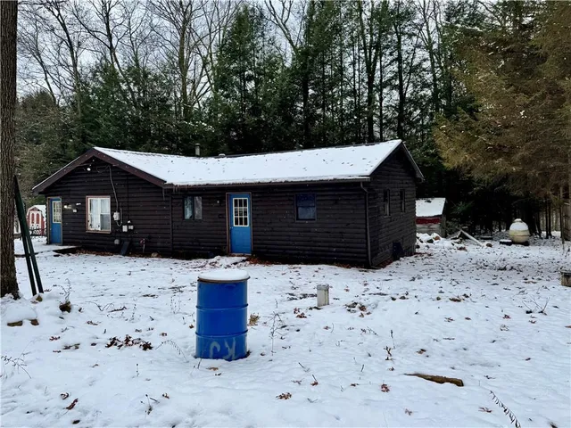 a front view of a house with a yard covered in snow