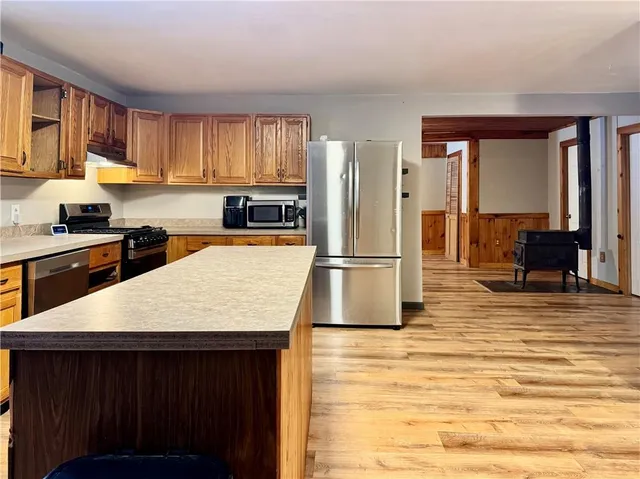 a kitchen with stainless steel appliances granite countertop a sink dishwasher stove top oven and refrigerator
