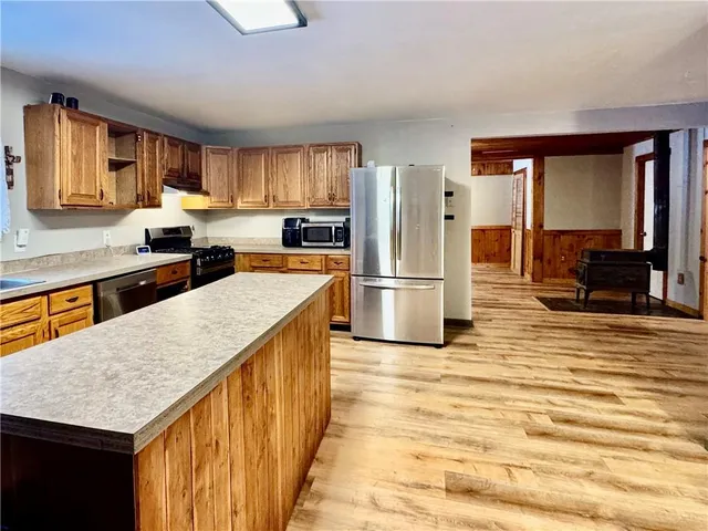 a kitchen with stainless steel appliances granite countertop a stove a sink dishwasher and a refrigerator