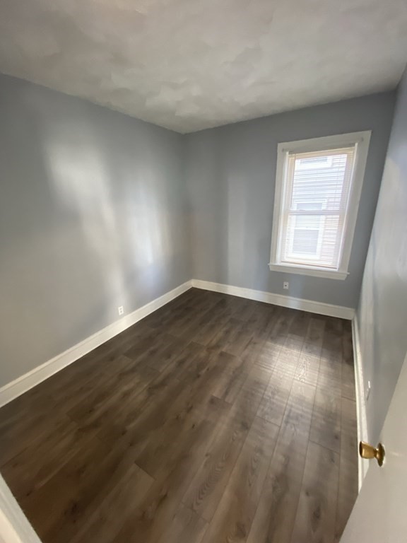 502 4th Street, Unit 2E Fall River, MA 02721 - Photo 3 of 5 an empty room with wooden floor and windows
