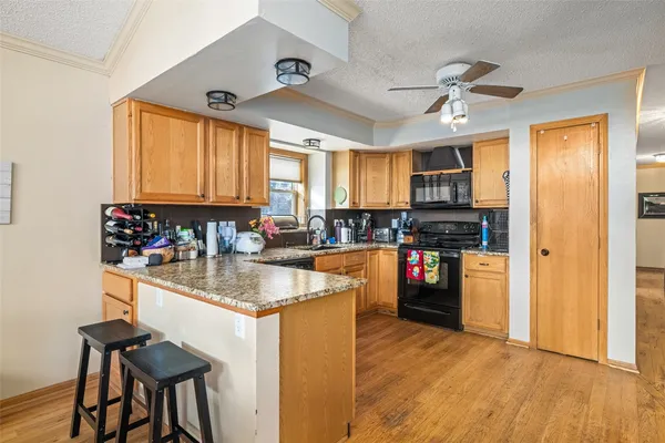 a kitchen with stainless steel appliances granite countertop a sink a stove and a refrigerator