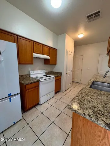 a kitchen with stainless steel appliances granite countertop a stove a sink and a refrigerator